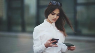Beyaz gömlekli çekici kadın, uçak, tren veya otobüs biletlerini kontrol eder. Kız uçuş için kayıt yaptırmaya çalışıyor..
