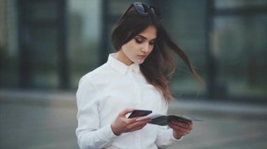 Beyaz gömlekli çekici kadın, uçak, tren veya otobüs biletlerini kontrol eder. Kız uçuş için kayıt yaptırmaya çalışıyor. İş kadını üzgün ve biletleri kontrol edemez. Giyim rahat