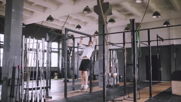 Atleta masculino caucasiano com tronco em forma e mãos fortes fazendo queixo ups ao ar livre. Bonito desportista loiro puxa para cima na barra horizontal do estádio. Chin up exercícios de bar . — Vídeo de Stock