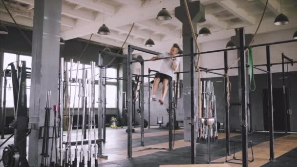 Caucasian male athlete with fit torso and strong hands doing chin ups outdoor. Handsome blonde sportsman pulls up on stadium horizontal bar. Chin up bar exercises. — Stock Video