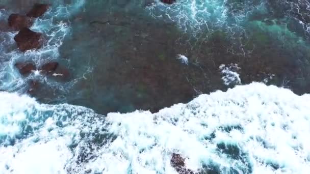 Vista aérea abstracta de las olas del océano que se estrellan en la costa rocosa . — Vídeos de Stock
