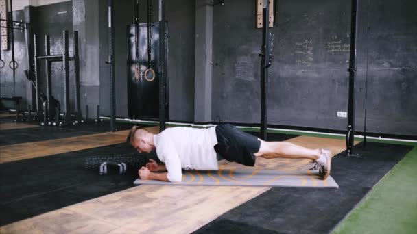 Sterke man doet plank zagen, exersize bij sportschool. — Stockvideo