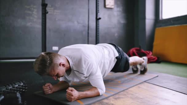 Starker Mann macht Brettersägen, trainiert im Fitnessstudio. — Stockvideo