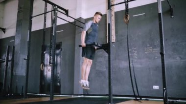 Genç erkek bir spor salonunda triceps dalış yapıyor.
