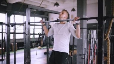 Güçlü orta yaşlı adam spor salonunda bar üzerinde çeker