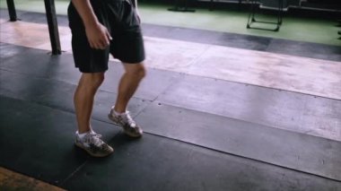 Çekici kas adam spor salonunda egzersiz ve antrenman yapıyor, kas yığını hareketleniyor.