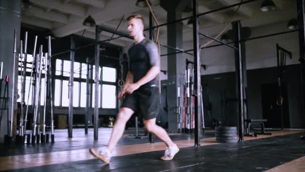 Atractivo músculo hombre ejercicio y entrenar en el gimnasio, la lengua muscular se pone en cuclillas — Vídeo de stock