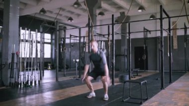 Erkek fitness eğitmeni modern plase de squat egzersiz gösteren.
