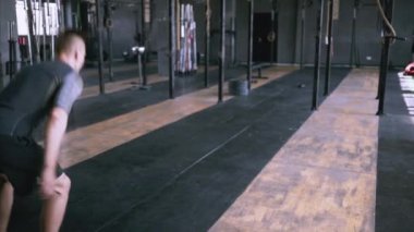 Erkek fitness eğitmeni modern plase de squat egzersiz gösteren.