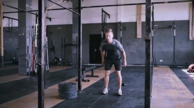 Erkek fitness eğitmeni modern plase de squat egzersiz gösteren.