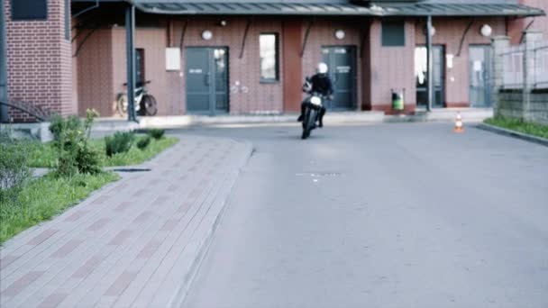 身穿皮手套和黑色帽衫的骑车人骑摩托车来了. — 图库视频影像