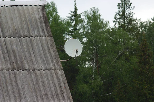 satellite TV antenna on the roof of a country house