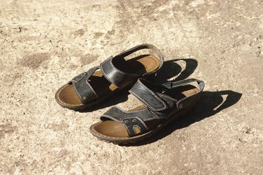 Beton bir platformda eski sandaletler