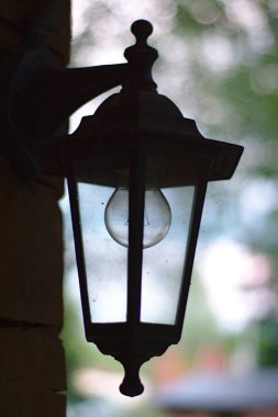 Ahşap bir evin duvarında klasik bir fener.