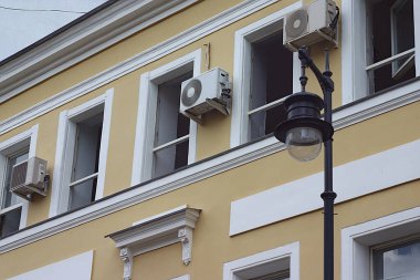 Binanın duvarında açık pencereler ve klima var.