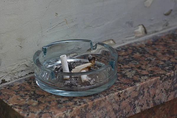 Asbak Met Sigarettenpeuken Een Stenen Plank — Stockfoto