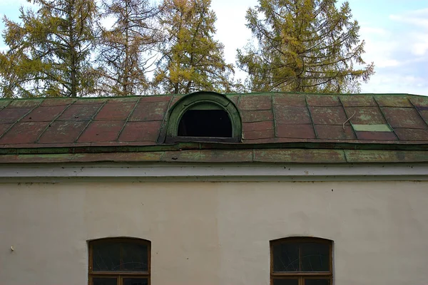fragment of an old building with a dormer window on the roof