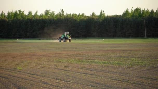 農薬除草剤からの噴霧でスプレー小麦畑を受精させる農場トラクター — ストック動画