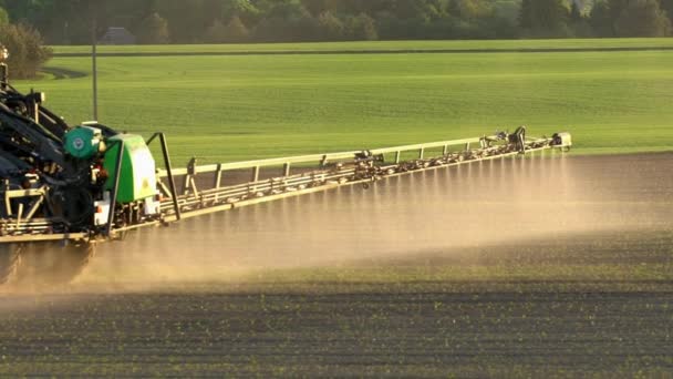 Spray de campo agrícola com herbicida. Handheld câmera lenta 100fps seguir tiro — Vídeo de Stock