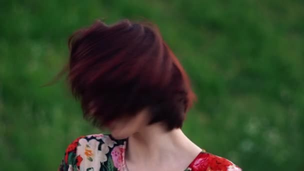 Femme ludique secouer la tête rousse et sourire en regardant la caméra. Mouvement lent — Video