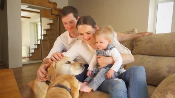Jovem família alegre com dois cães animais de estimação em casa. Emoções positivas — Vídeo de Stock