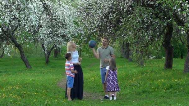 Família ativa pegar bola na natureza. As pessoas jogam com bola no jardim. Movimento lento — Vídeo de Stock