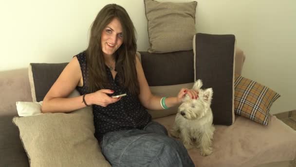 Wanita bahagia tersenyum melihat kamera dan membelai hewan peliharaan anjingnya — Stok Video
