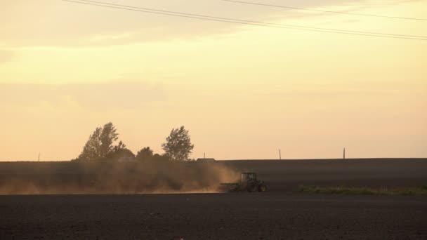 カントリーハウスの近くのトラクターの播種場。夕日の空。静的ショット. — ストック動画