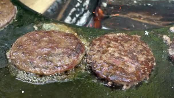 Stegning hamburger kød på jernplade og brændende brænde på baggrund – Stock-video