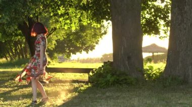 Renkli elbise aktif kadın modeli akşam gün batımında açın. yavaş çekim