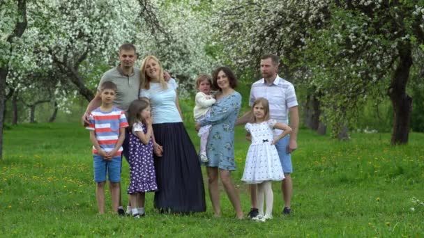 Familien, Eltern mit Kindern posieren im Frühlingsgarten vor der Kamera — Stockvideo