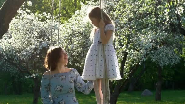 Young mother and cute daughter in beautiful blossom garden. Slow motion — ストック動画