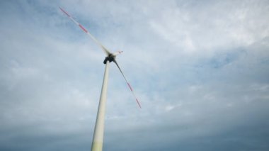 Rüzgar türbini elektrik jeneratör pervane bulutlu gökyüzü arka plan üzerinde döndürmek