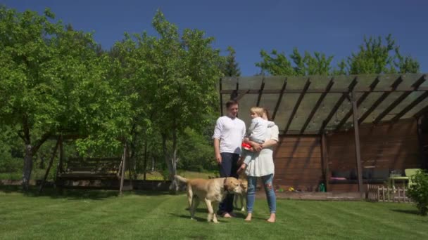 Gelukkig familie man vrouw en kind met hond tijd doorbrengen samen in huis tuin — Stockvideo