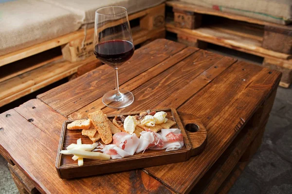 Italian food on a wooden chopping with a red wine glass — Stock Photo, Image