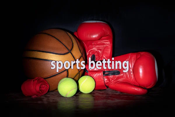 sports betting balls and boxing gloves on black background