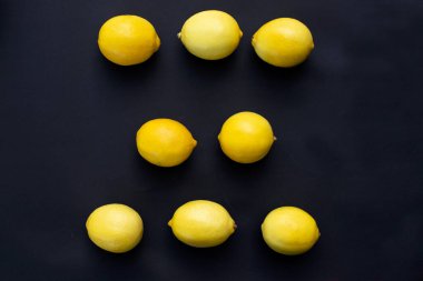 Siyah arka planda sulu limonlar. Limon meyvesi, narenciye, minimum konsept, C vitamini yaratıcı minimalist arka plan..