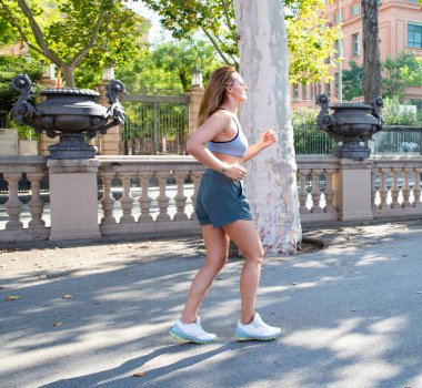 Aktif kıyafetli bir kadın güvenli bir şekilde yürüyor. Kentsel fitness etkinliği