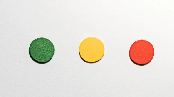 Different colorful circles wooden on white background. Geometric shapes red, green, yellow colors, top view. Concept of geometry. Copy space. Children educational logical task. Flat lay.