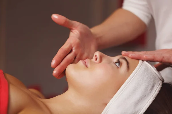 Spa treatment. Face massage. Massage the forehead and chin area client close-up.