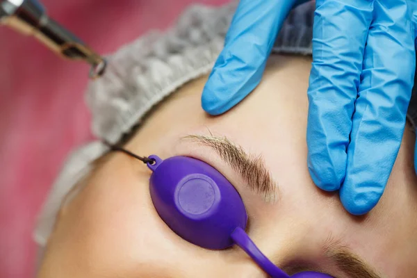 Laser removal of tattoo eyebrows. Shooting closeups. Cosmetic medical procedure in a beauty salon.