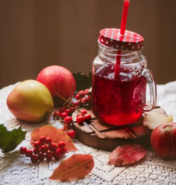 Beyaz bir açık peçete üzerinde sarı yapraklar, elma ve kırmızı çilek Sonbahar kompozisyon, bir cam kupa kırmızı komposto, sonbahar natürmort