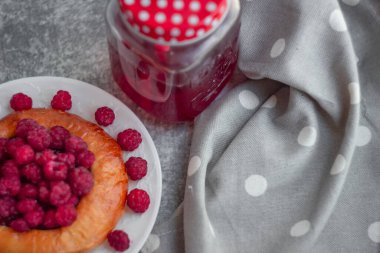 Peynirli kek çöreği, beyaz tabakta büyük ahududu, yakın plan, bulanık arka plan.