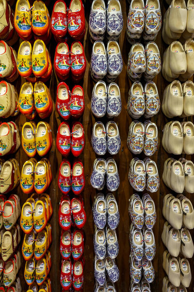 Set of different colorful vintage Dutch wooden clogs on display.