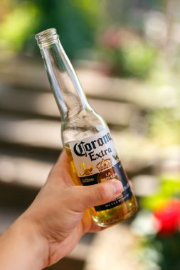 El iyle bahçede buz gibi Corona birası, Londra, İngiltere, 26 Haziran 2018.