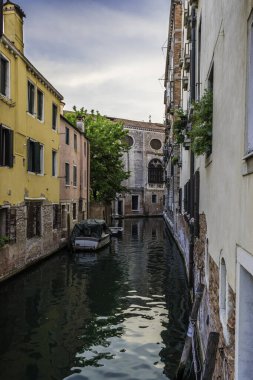 Gondolcu gondolunu çekiyor ve İtalya, Venedik 'te alçak bir köprünün altından geçmeye hazırlanıyor.