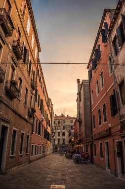 Gondolcu gondolunu çekiyor ve İtalya, Venedik 'te alçak bir köprünün altından geçmeye hazırlanıyor.