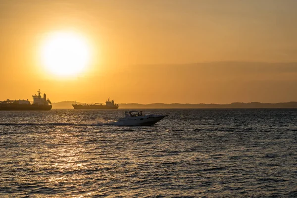 Brezilya, Salvador 'daki tüm azizlerin körfezinde gün batımında yelken açan bir sürat teknesi.