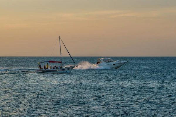 Brezilya, Salvador 'daki tüm azizlerin körfezinde gün batımında yelken açan bir sürat teknesi.