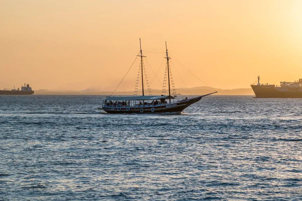 Brezilya, Salvador 'daki tüm azizlerin körfezinde gün batımında yelken açan bir sürat teknesi.